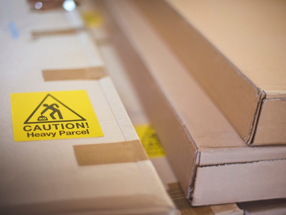 kartónové balíky označené značkou „caution – heavy parcel“  (opatrne – ťažký balík).